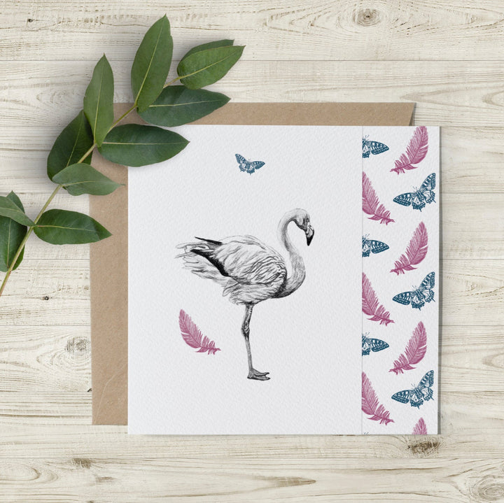 Eco-friendly flamingo and butterfly greeting card featuring a hand-drawn charcoal flamingo, pink feathers, and blue butterflies. Sustainably made in the UK.