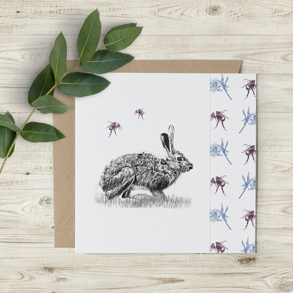 Eco-friendly hare and bee greeting card with hand-drawn charcoal hare, coloured bees, and flowers. Sustainably made in the UK.