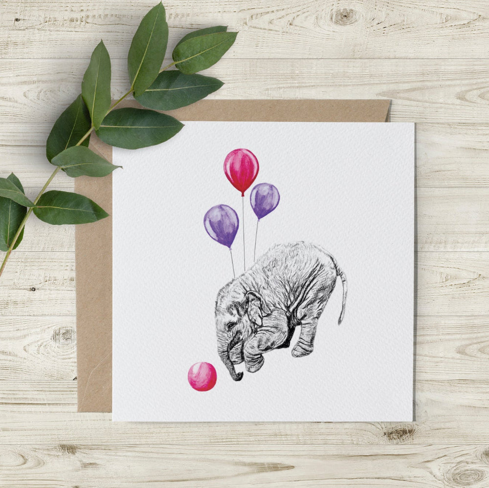 Eco-friendly Happy Birthday card featuring a hand-drawn baby elephant playing with a pink ball, surrounded by pink and purple balloons