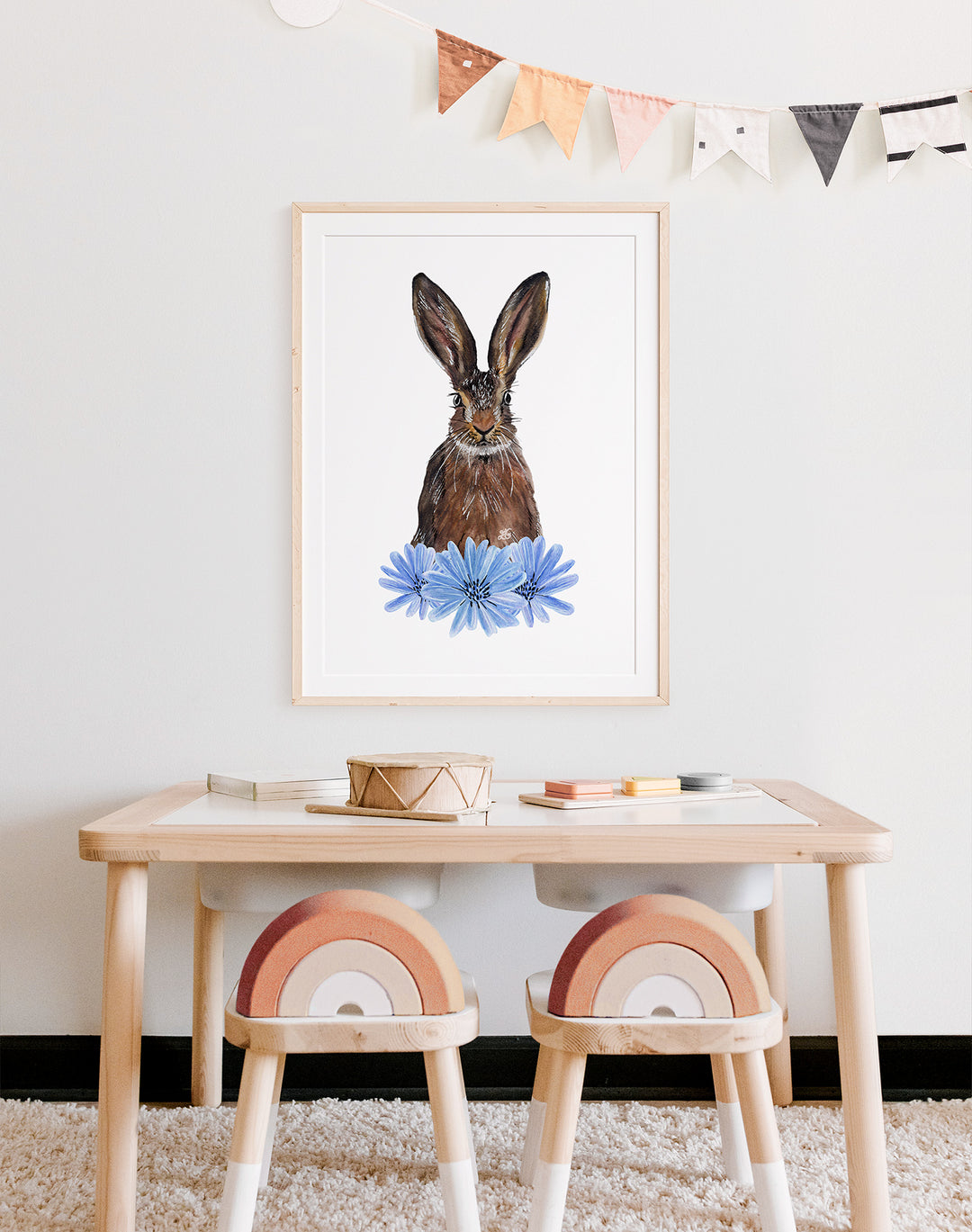 Hand-drawn watercolour art print of a hare displayed above a child's table and chairs in a bedroom, showcasing nature-inspired nursery décor, sustainable art prints for children, and whimsical animal illustrations.