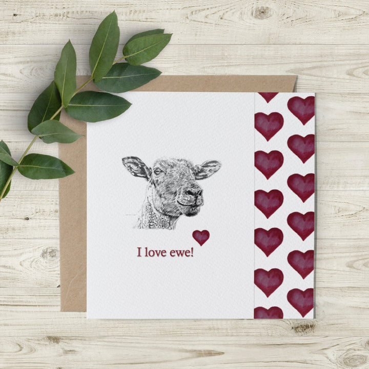 Eco-friendly 'I Love Ewe' card with hand-sketched sheep by Emma Gorton, featuring red watercolour hearts. UK-made and artist-designed