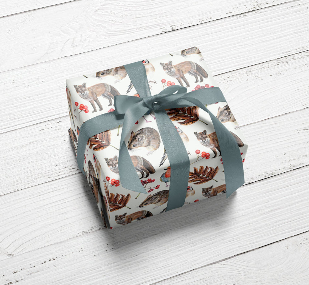 A beautifully wrapped gift featuring nature-inspired fox, robin, and woodland sketch gift wrap, finished with a subtle blue bow—perfect for licensed children’s décor and wildlife-themed product collaborations.