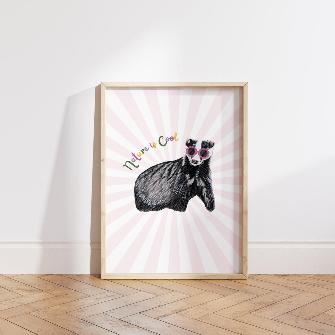 Hand-drawn badger wearing pink sunglasses with “Nature is Cool” text on a pink and white sunburst background, framed as a giclée art print.