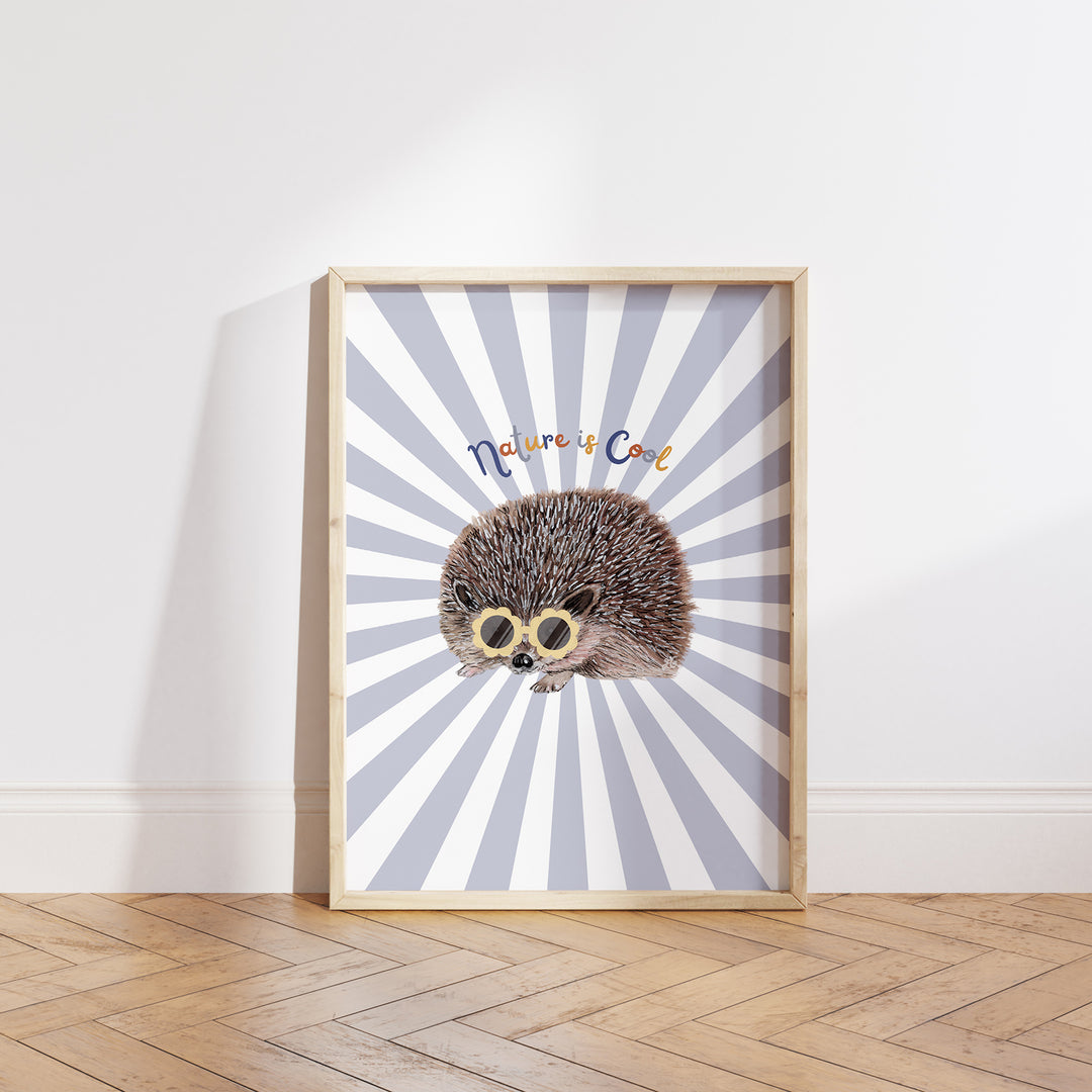 Hand-drawn hedgehog wearing yellow sunglasses with “Nature is Cool” text on a blue and white sunburst background, framed as a giclée art print.