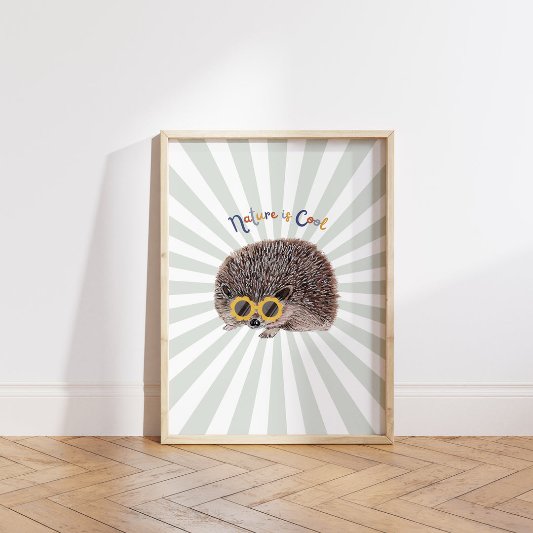 Hand-drawn hedgehog wearing yellow sunglasses with “Nature is Cool” text on a green and white sunburst background, framed as a giclée art print.