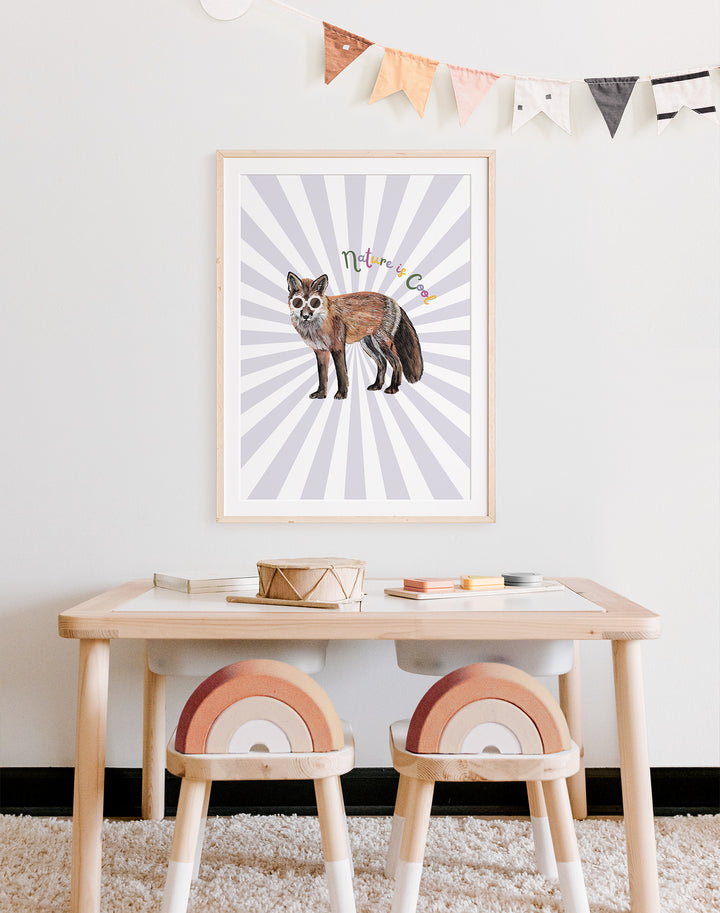 "nature is cool" art print framed and on wall of child's playroom desk. The print is of a fox against a lilac 
starburst.