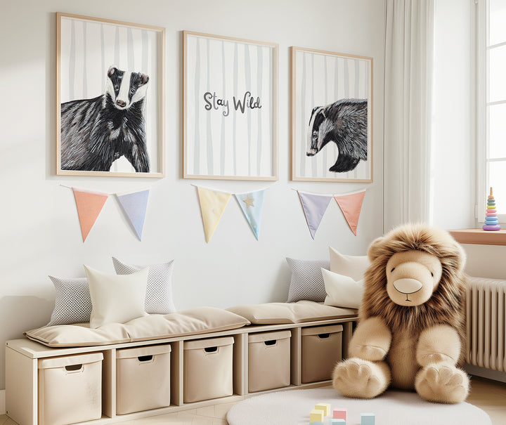 child's bedroom with soft toy lion and art print set on the wall with two badgers against a grey striped background on either side of a print saying "stay wild"